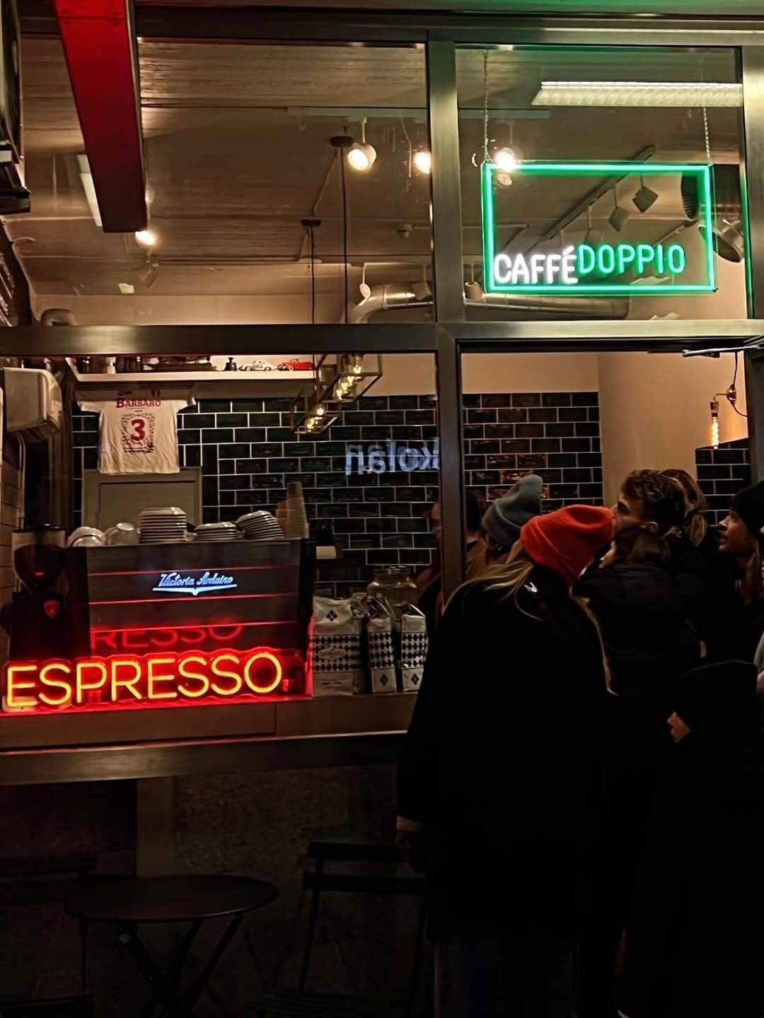 Espressohörnan hos DOPPIO — neonskylten ESPRESSO och Victoria Arduino-maskinen bakom disken.