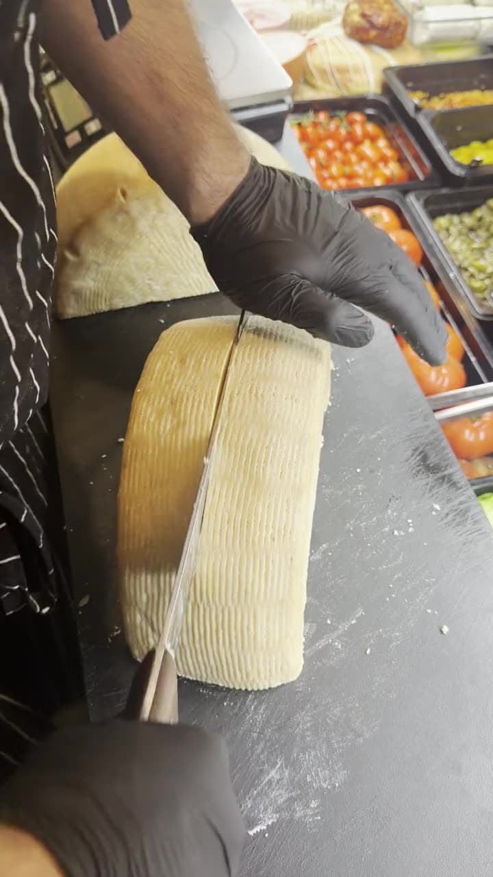 Pecorino träds med ost-tråd, kryddtråg synliga bredvid.